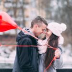 a woman and a man hugging face to face holding heart shaped balloons showing the power of love